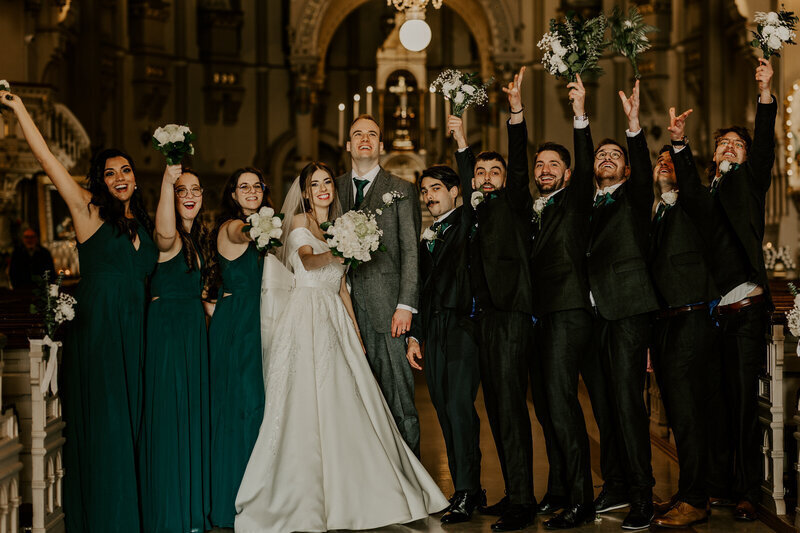 Mariés entourés de leurs amis et demoiselles d'honneur habillées en vert dans l'église, à Montréal lors d'une séance photo mariage.