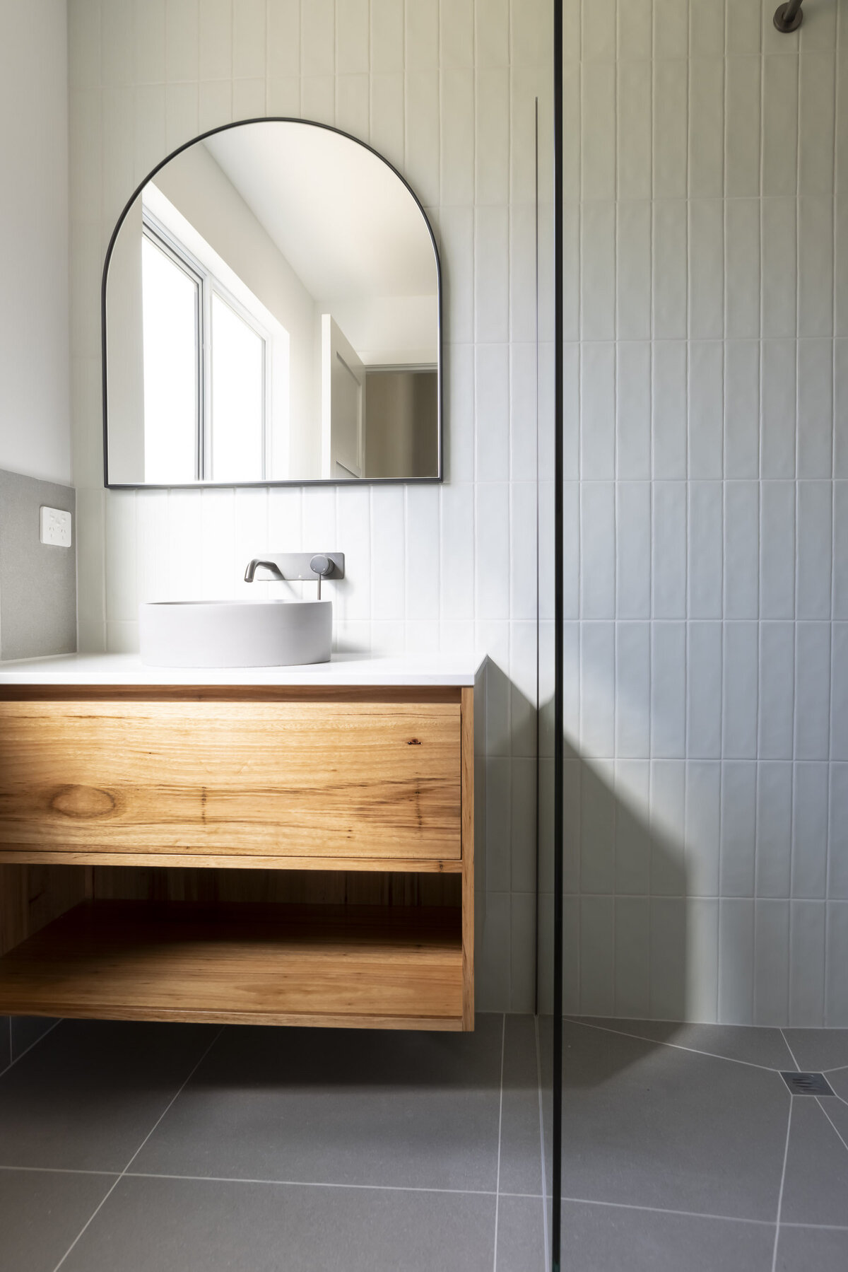 Natural light beams into modern bathroom in custom home by WBK building