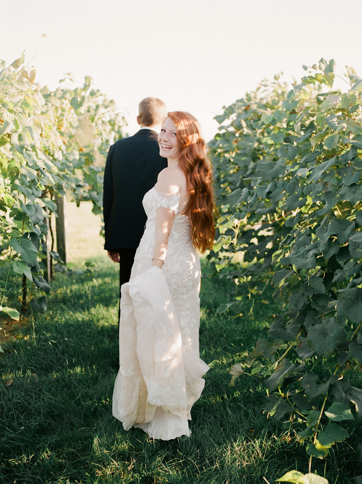 couple walking through vineyard together