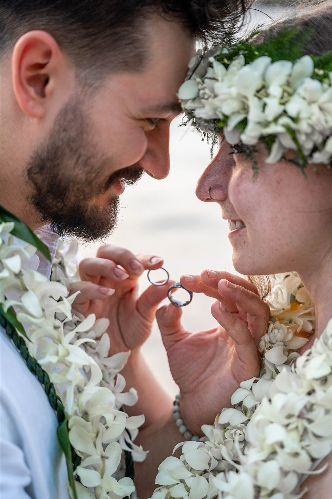 Couple holding rings in between them for elopement, taken by team of big island wedding photographers
