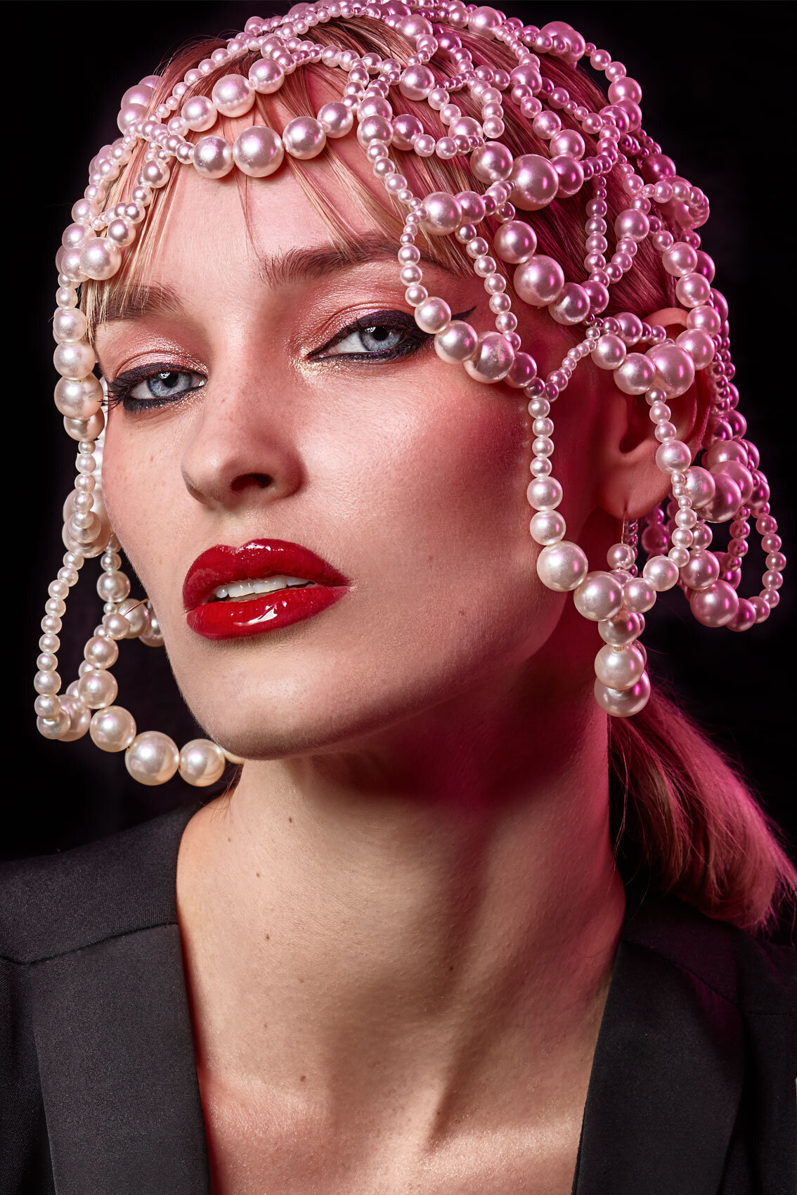 High-fashion portrait of Pernilla Fransander with vibrant makeup and striking accessories, captured by Ylva Erevall.
