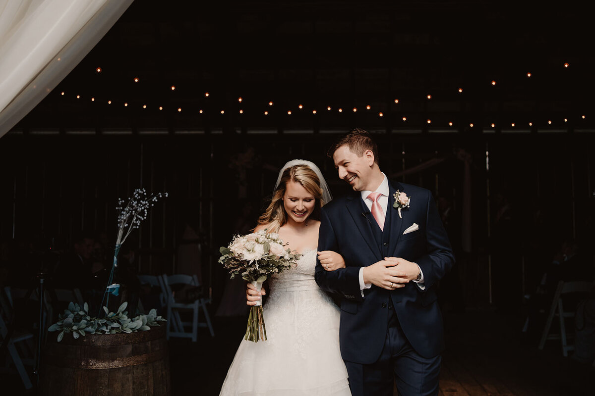A newlywed couple walking arm in arm smiling 