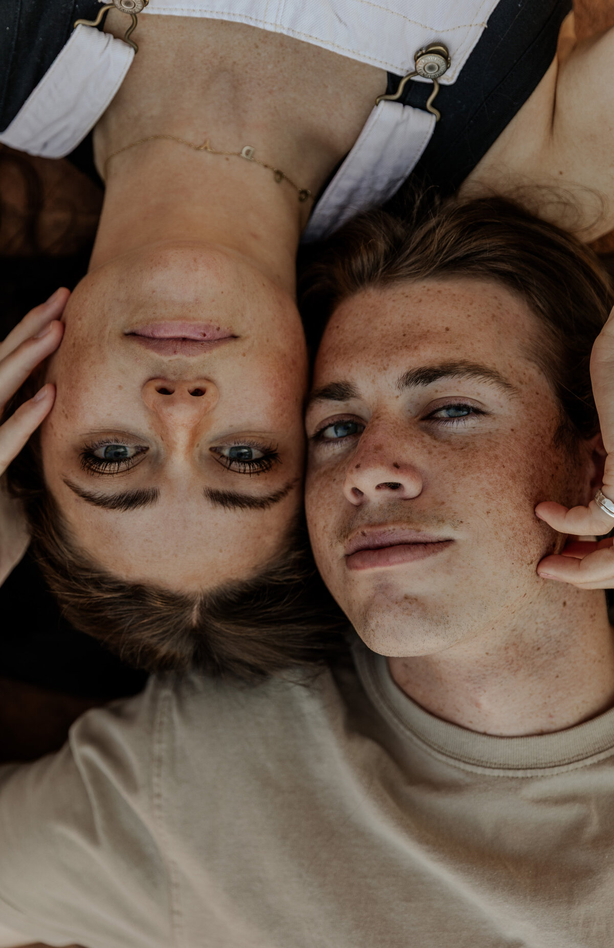 Serious photo of couple laying down close up of their faces 