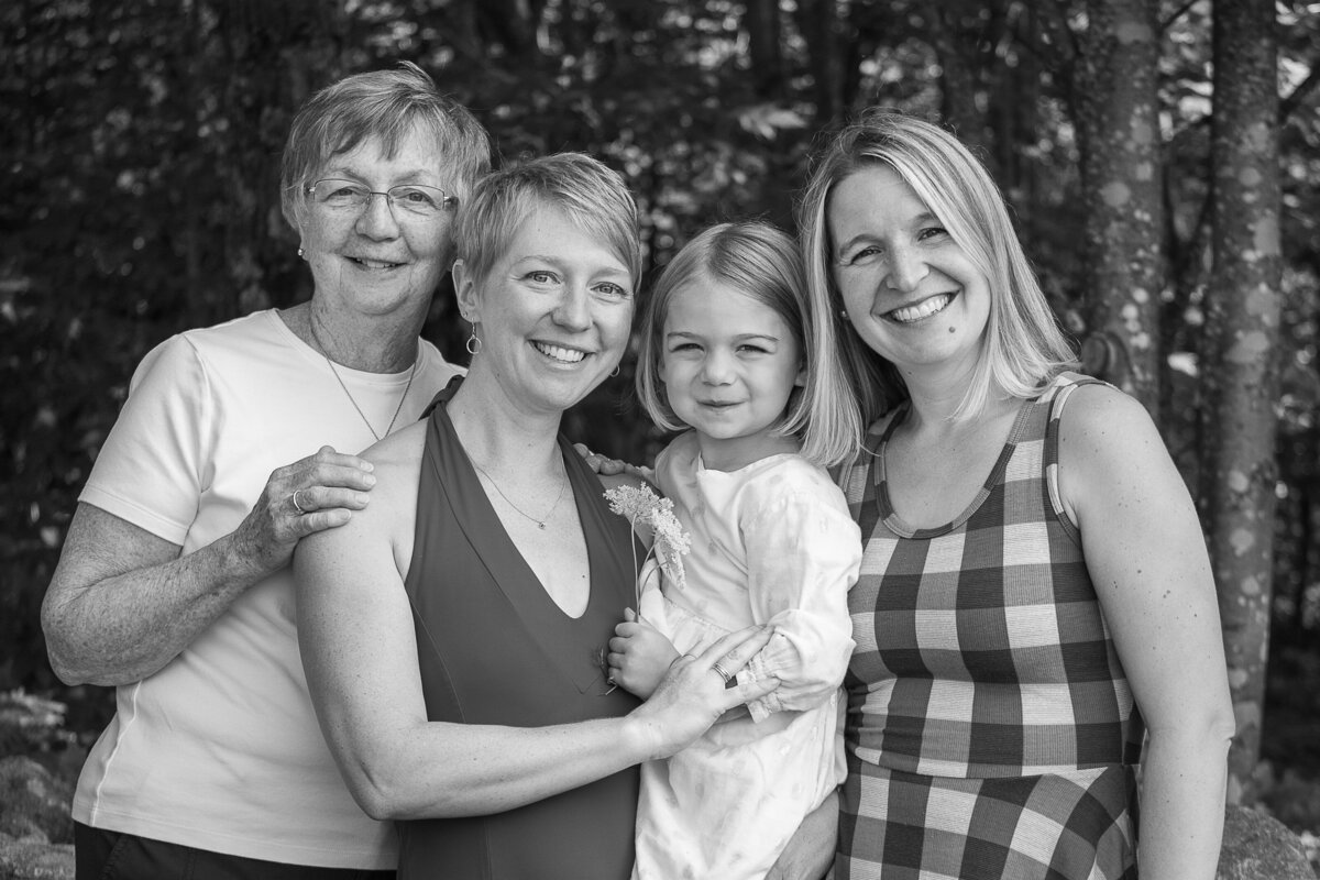 Grandmother, daughter, granddaughter and daughter in law post for a 3 generation portrait in Waterford, Maine