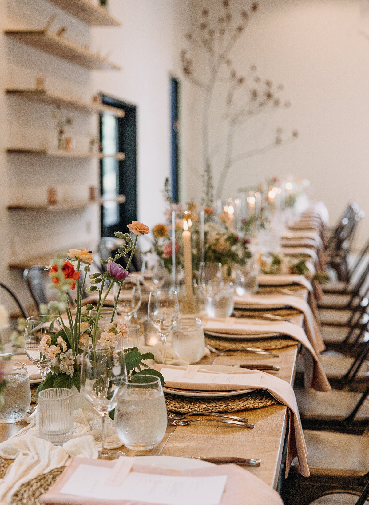 Long tables decorated with colourful floral centrepieces for a wedding at Verger du Flanc Nord.