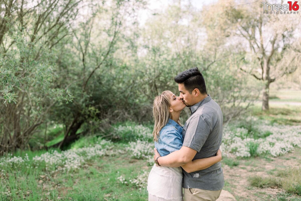 Engaged couple share a sweet kiss at Talbert Regional Park