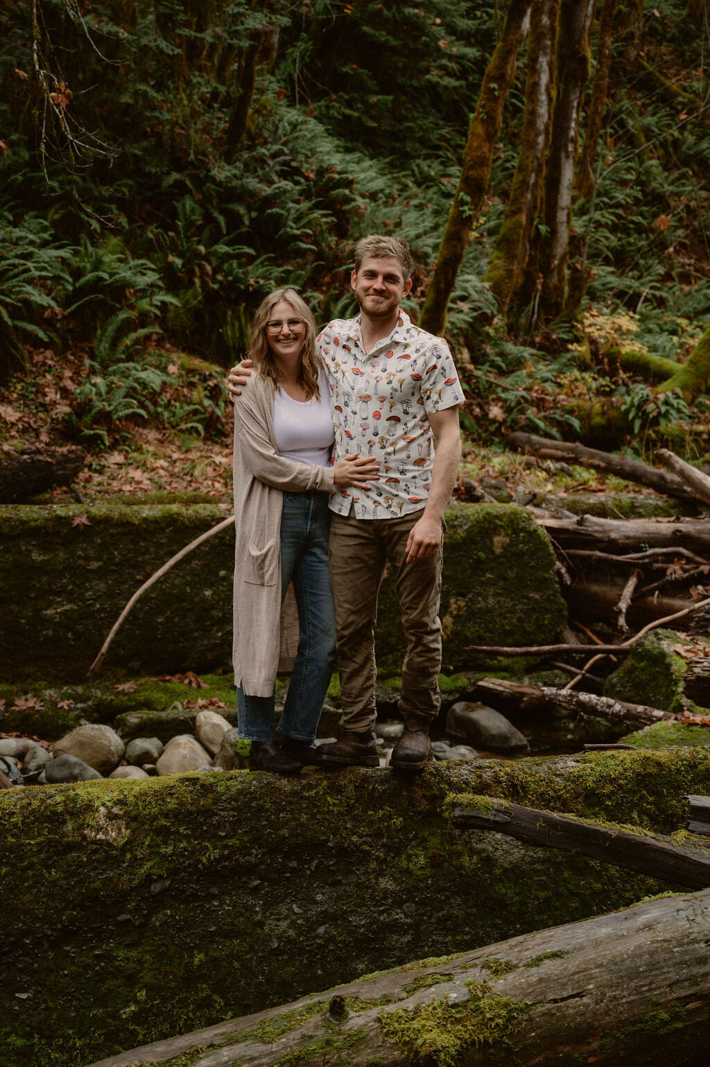 couple standing on concrete wall in the forest