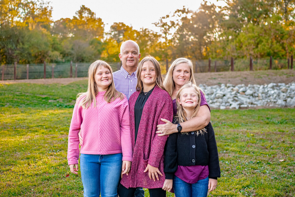 Mom and dad pose with their three teen daughter for family pictures in Huntsville Alabama