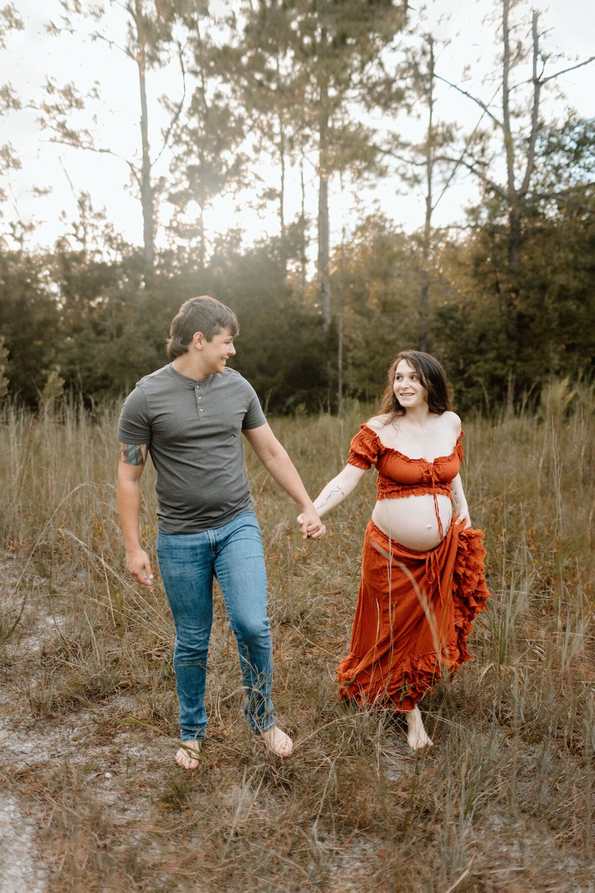 Maternity photography couples photo pregnant woman with husband in field in Tampa Bay, Florida Nadine B Photography