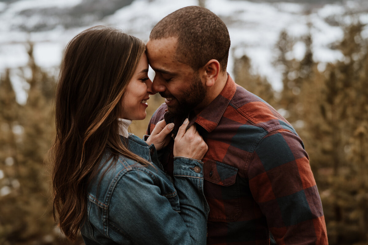 Close-up of smiling couple leaning in during cozy Sapphire Point engagement session.