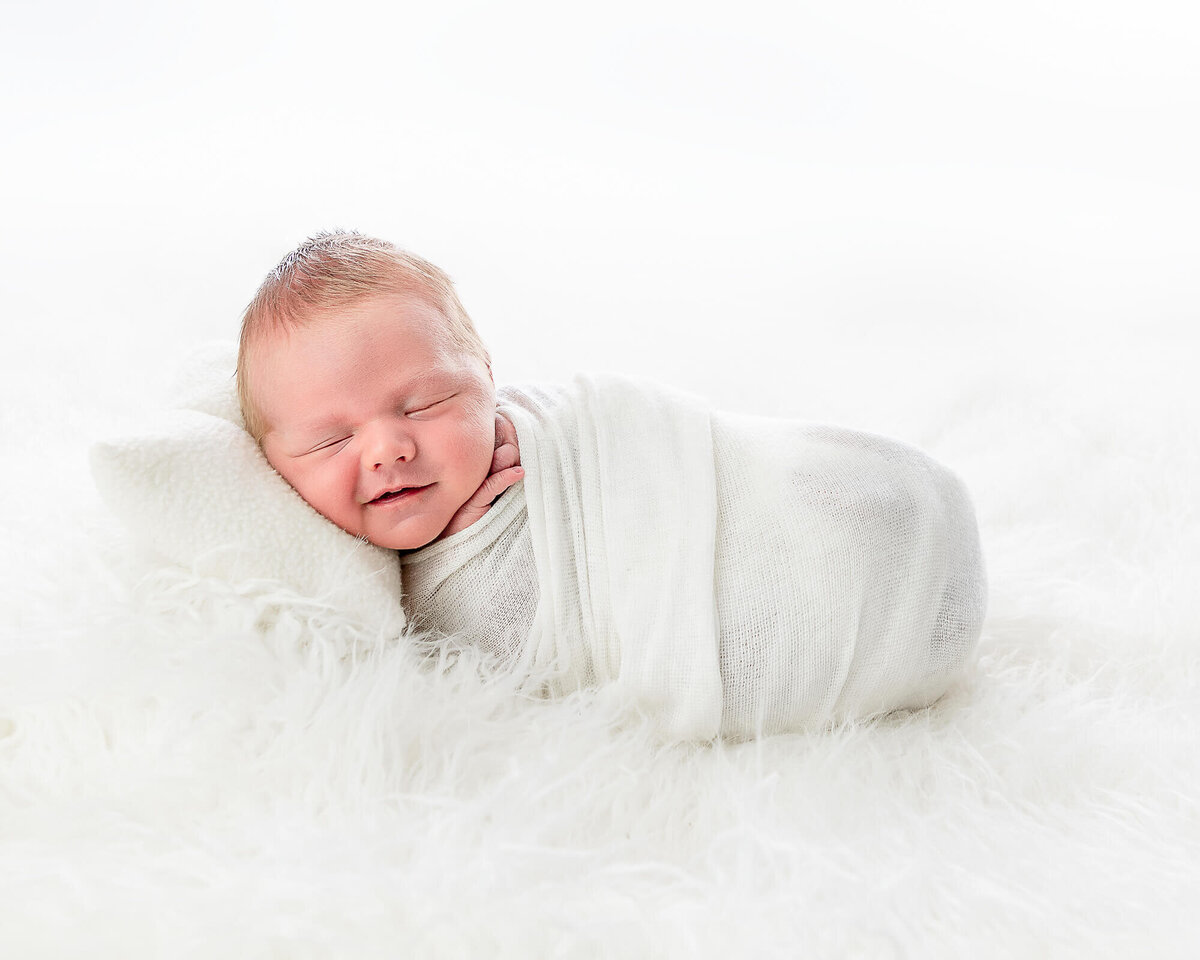 baby swaddled in white portrait