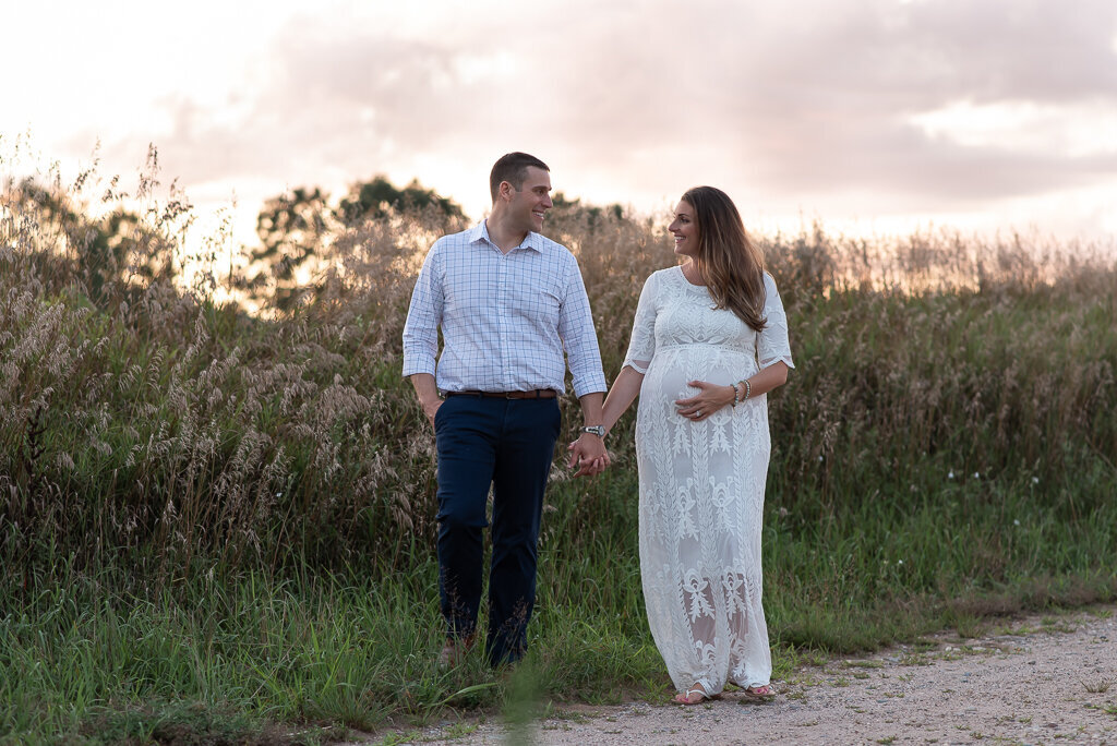 Pregnant couple holding hands and smiling at sunset maternity field session | Sharon Leger Photography | CT Newborn & Family Photographer | Canton, Connecticut