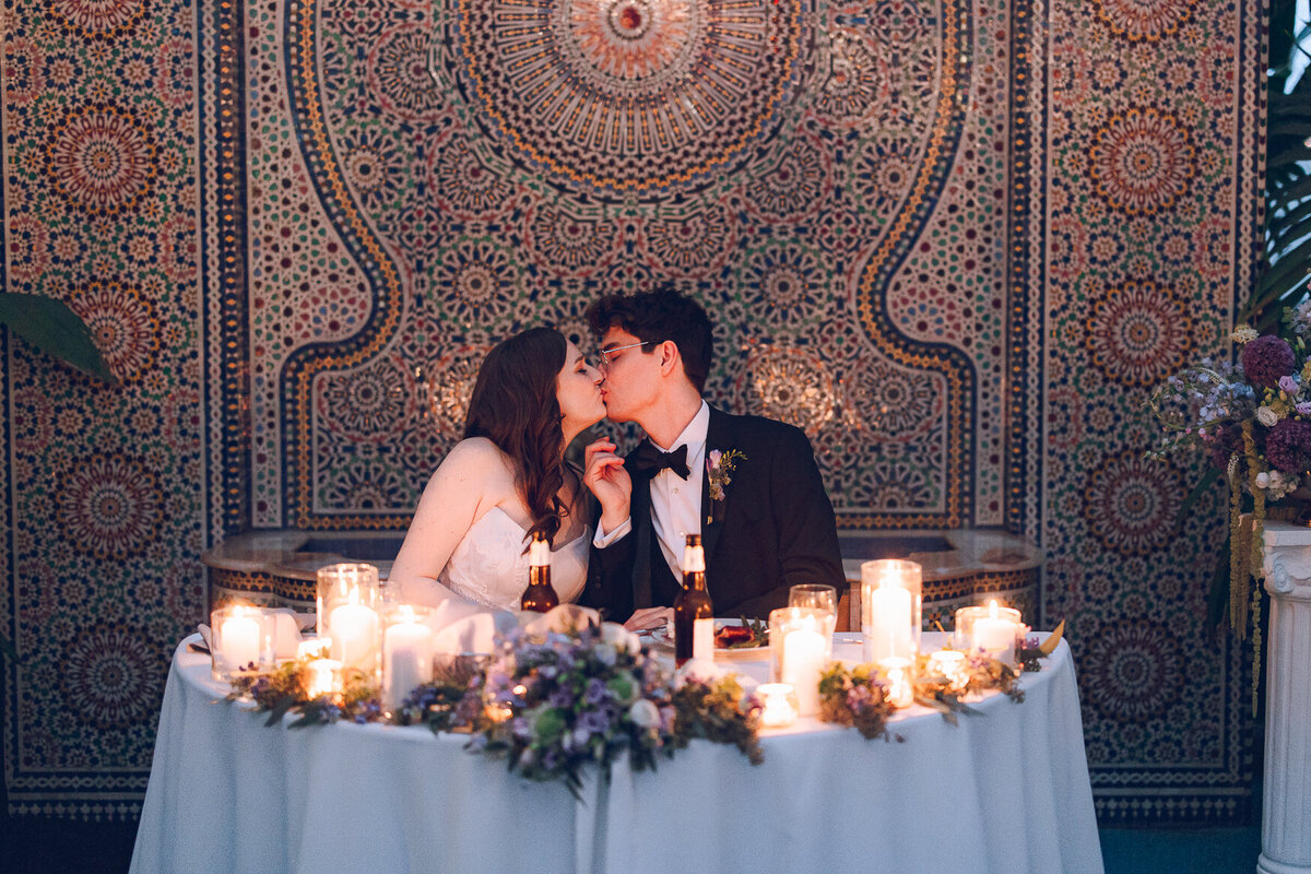 A couple shares a kiss during their reception at the Garfield Park Conservatory in Chicago