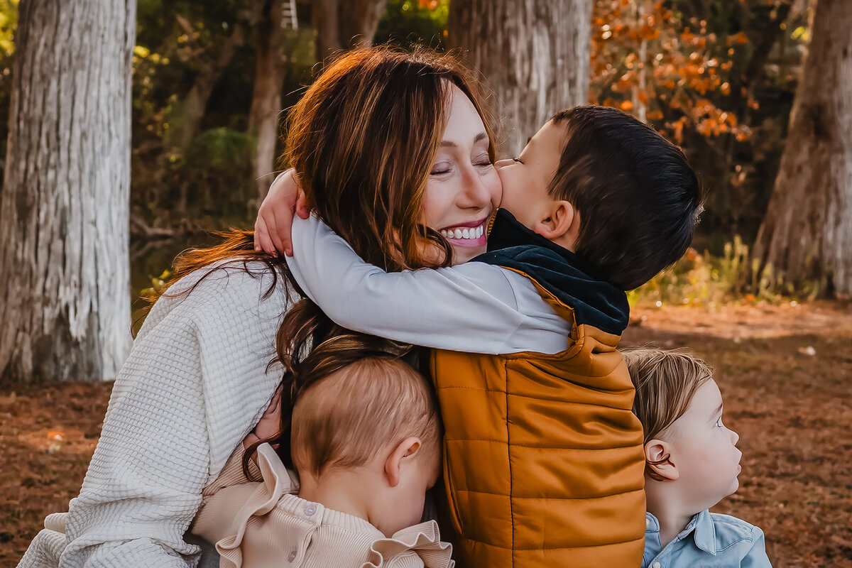 Sweet moment of young boy hugging grandmother during family session at Cypress Bend in New Braunfels, Texas.