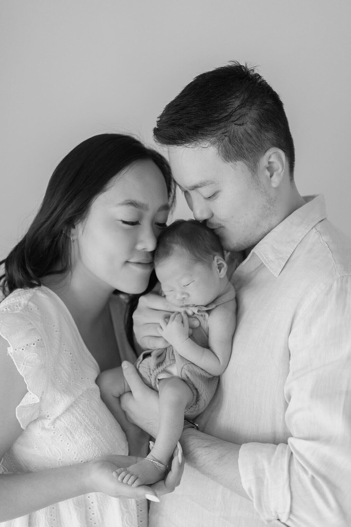 Witness the love of a Chinese couple holding their precious newborn, cherishing each moment in their Gold Coast home.
