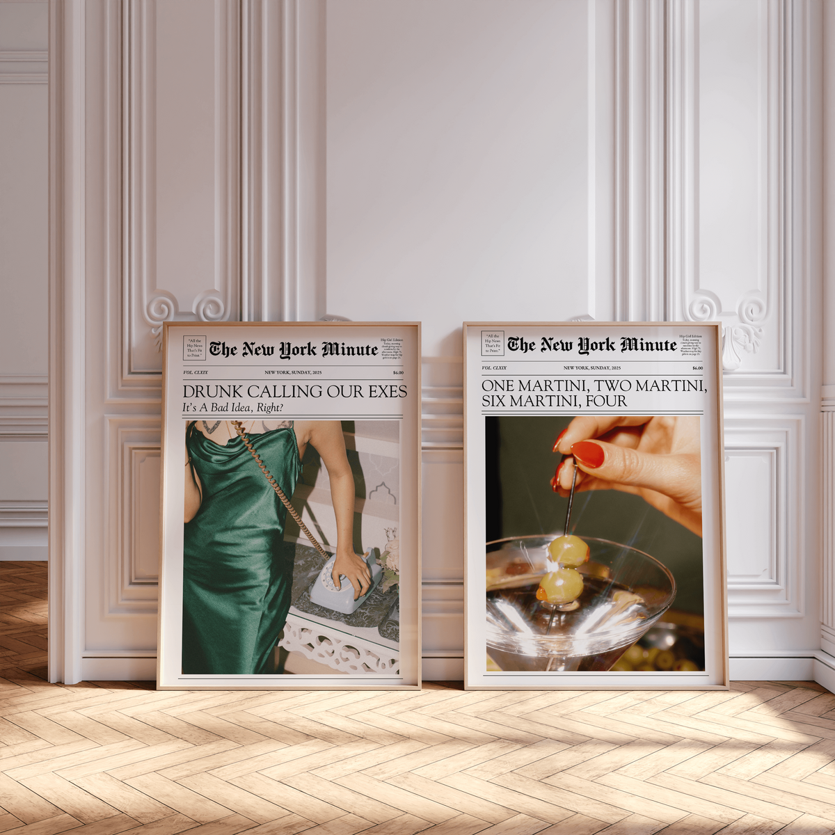 Two framed posters styled as newspaper covers by Sweet Pea Ink Designs are propped against a white ornate wall; one features a woman in a green dress, the other highlights brand design with a hand holding a martini and olives.