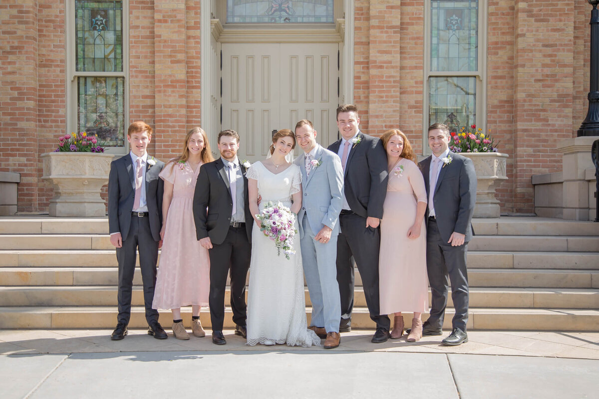 bride and groom posing with family