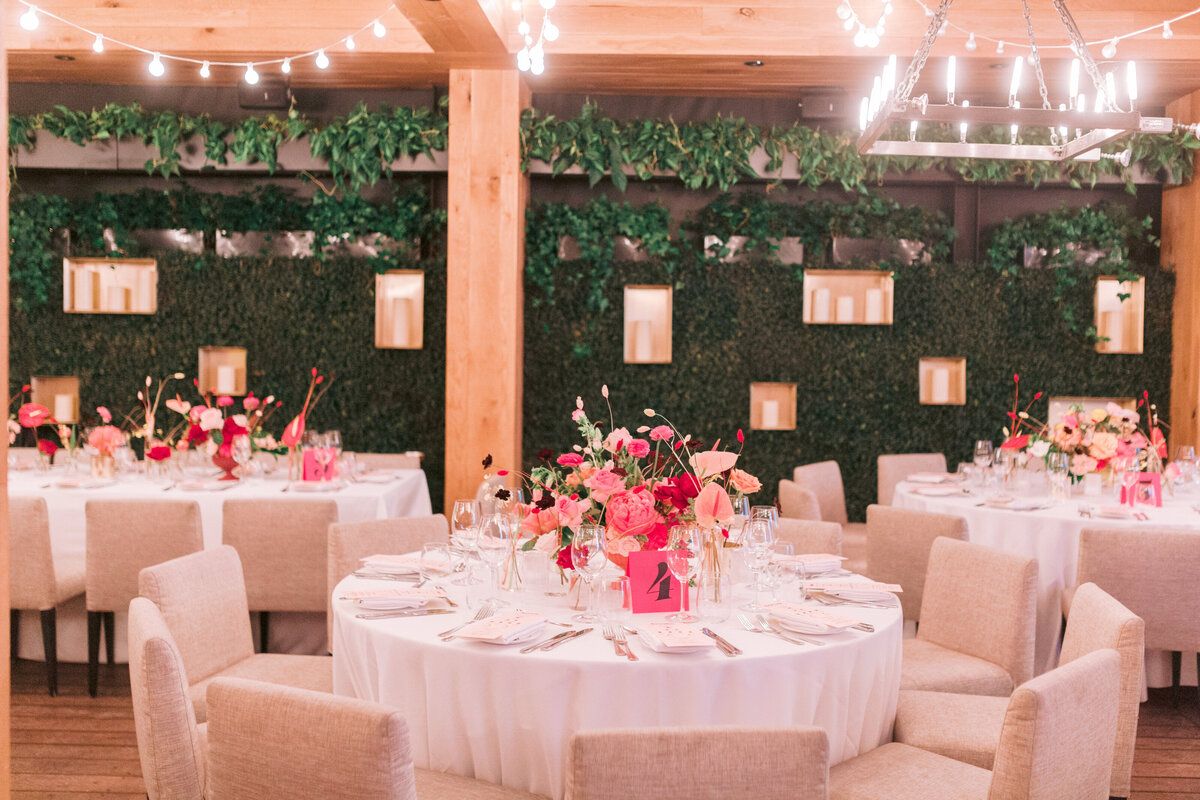 Restaurant Beatrice decorated for a wedding reception with greenery and centrepieces of bright pink flowers.