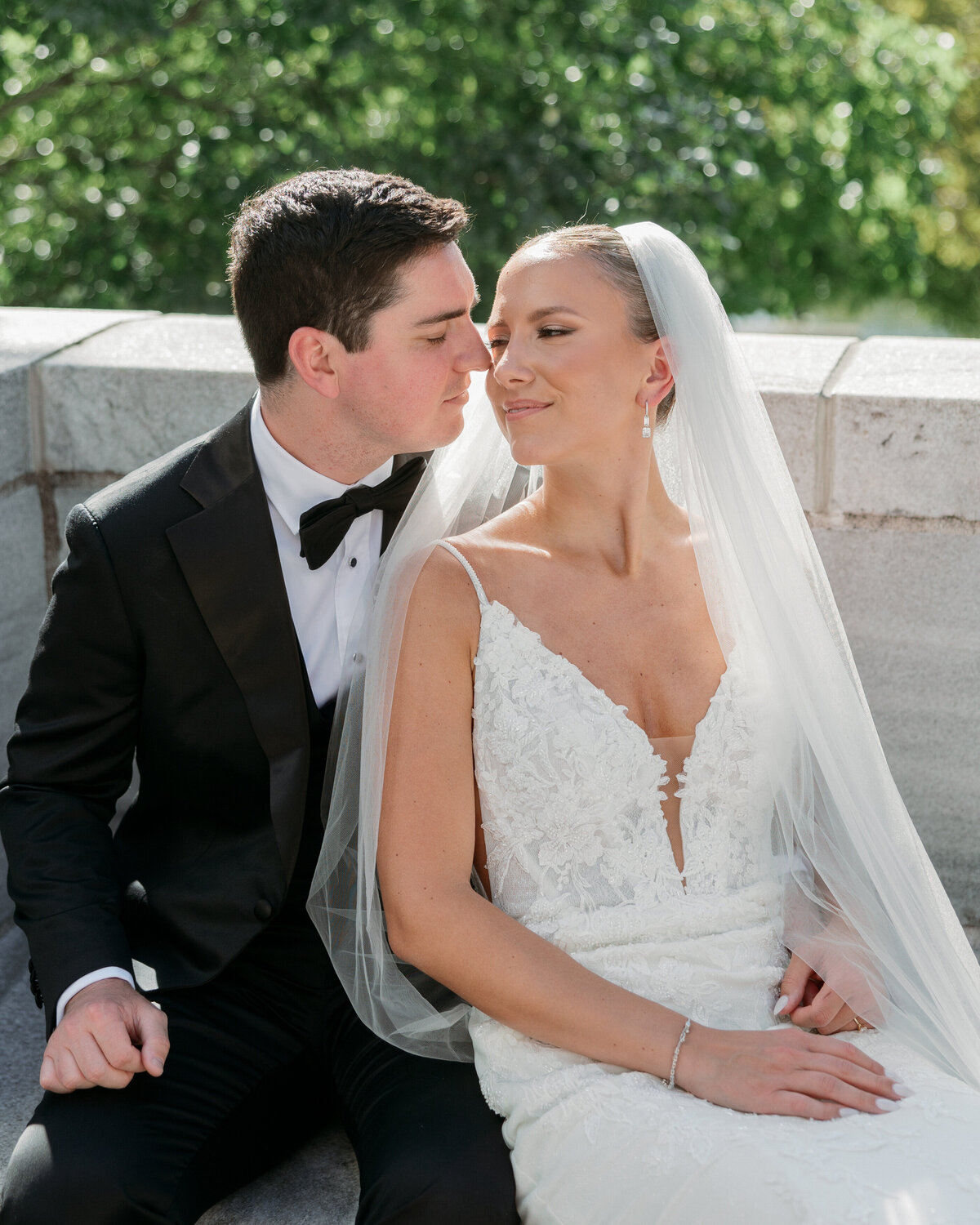 Intimate moment of groom leaning in to kiss bride’s cheek as she smiles, photographed in Philadelphia.