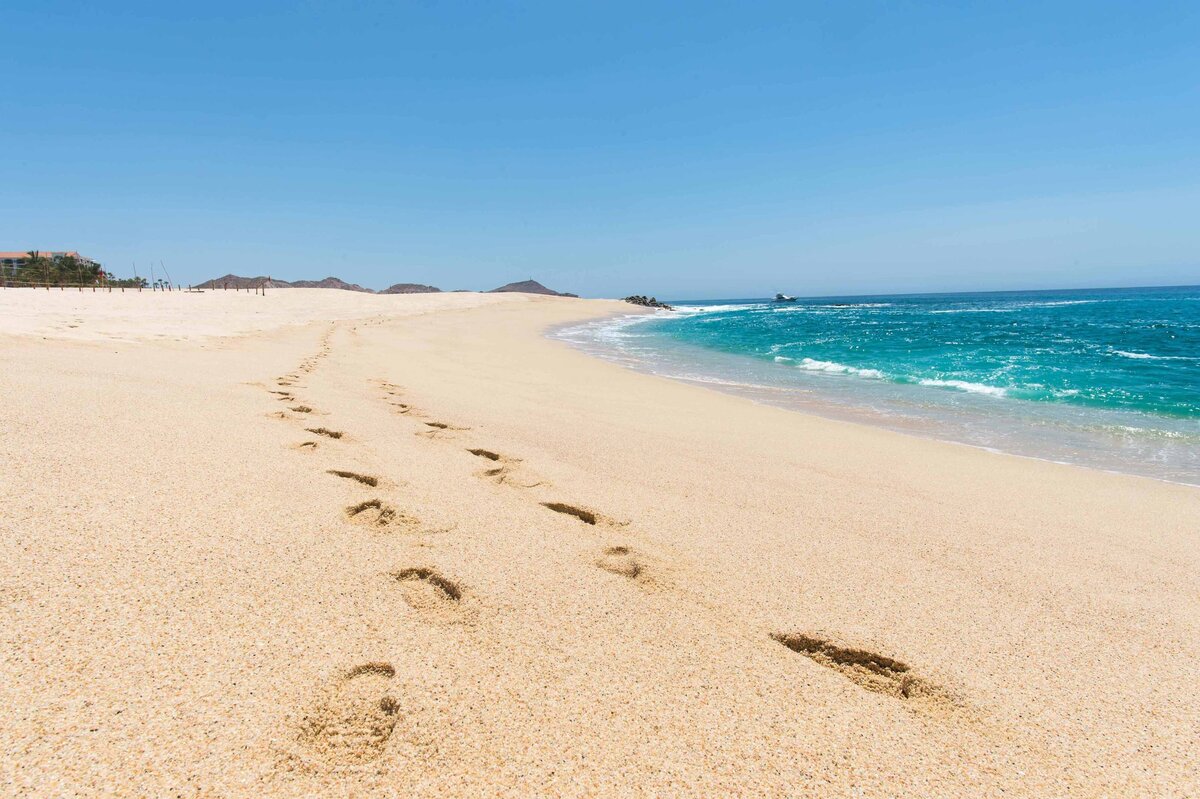 Footprints leading to the horizon on the beach at Los Cabos with turquoise  water