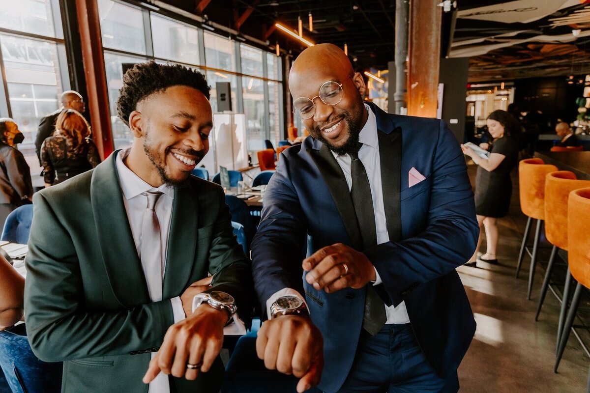 Groom and best man looking at their watches