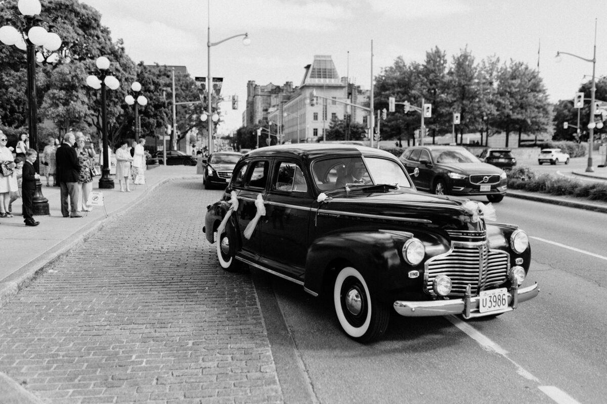 The groom and bride speeding away in their car after the wedding ceremony at Notre Dame Basilica