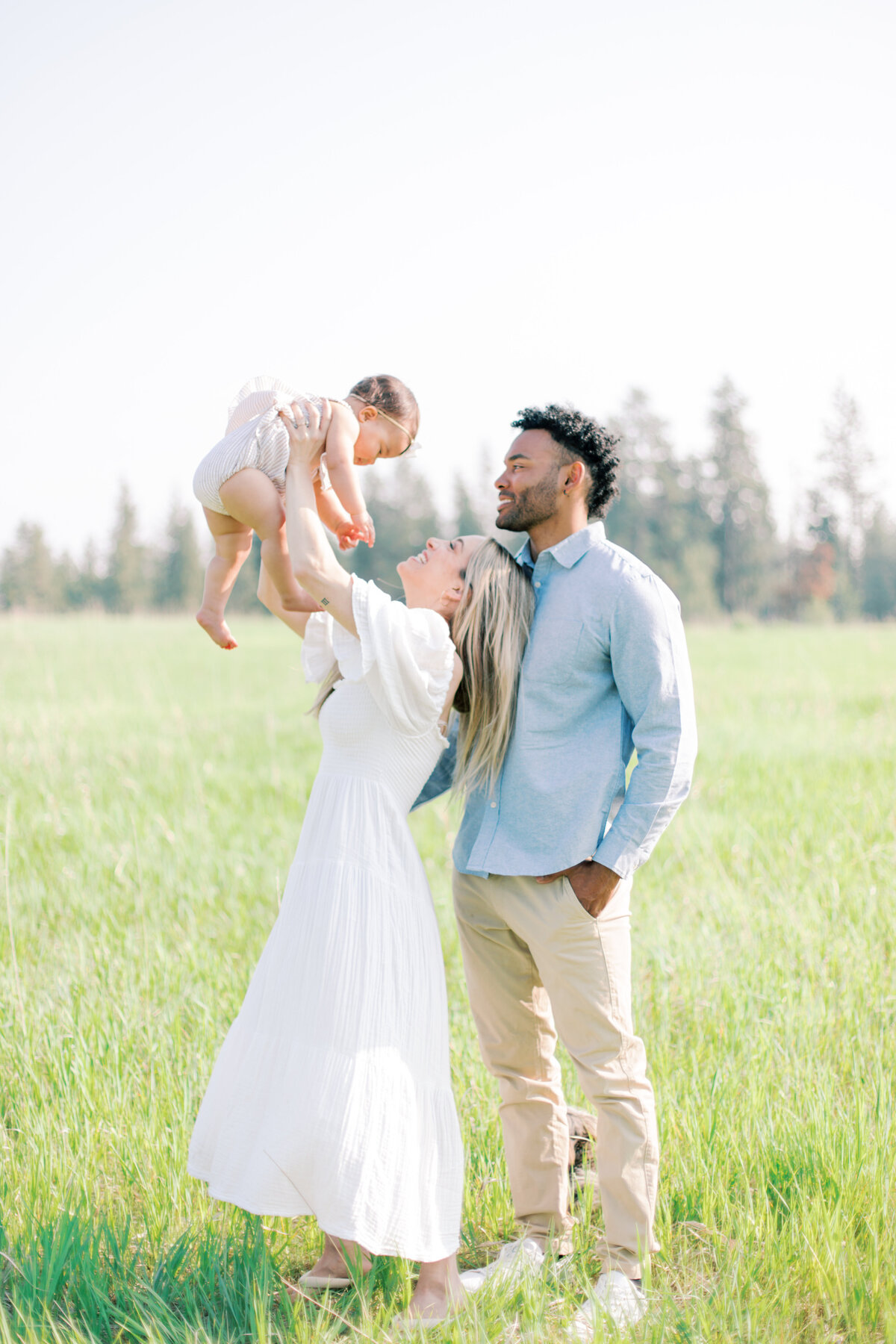 family in a field playing by spokane photographers