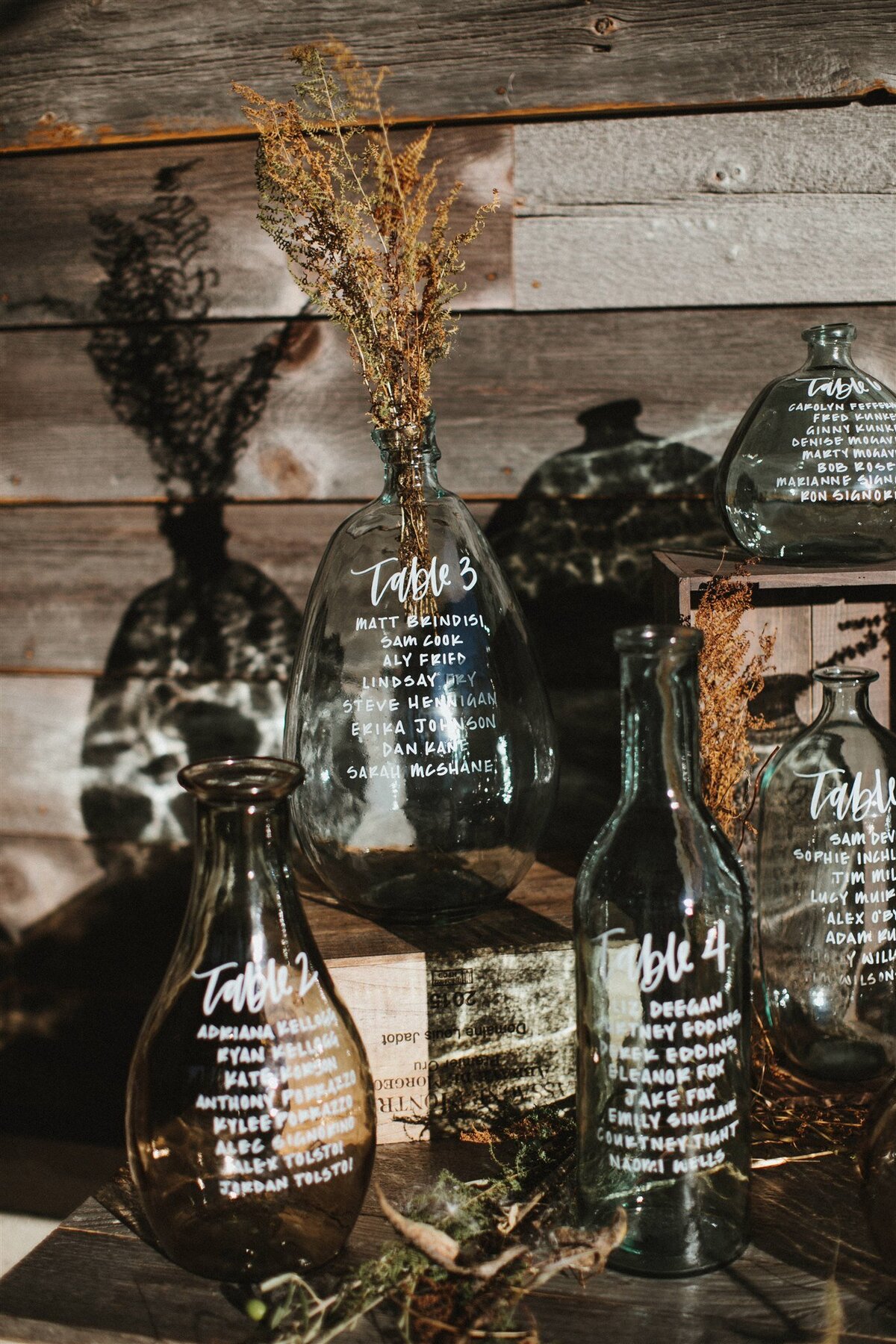 Glass bottle seating chart with calligraphy