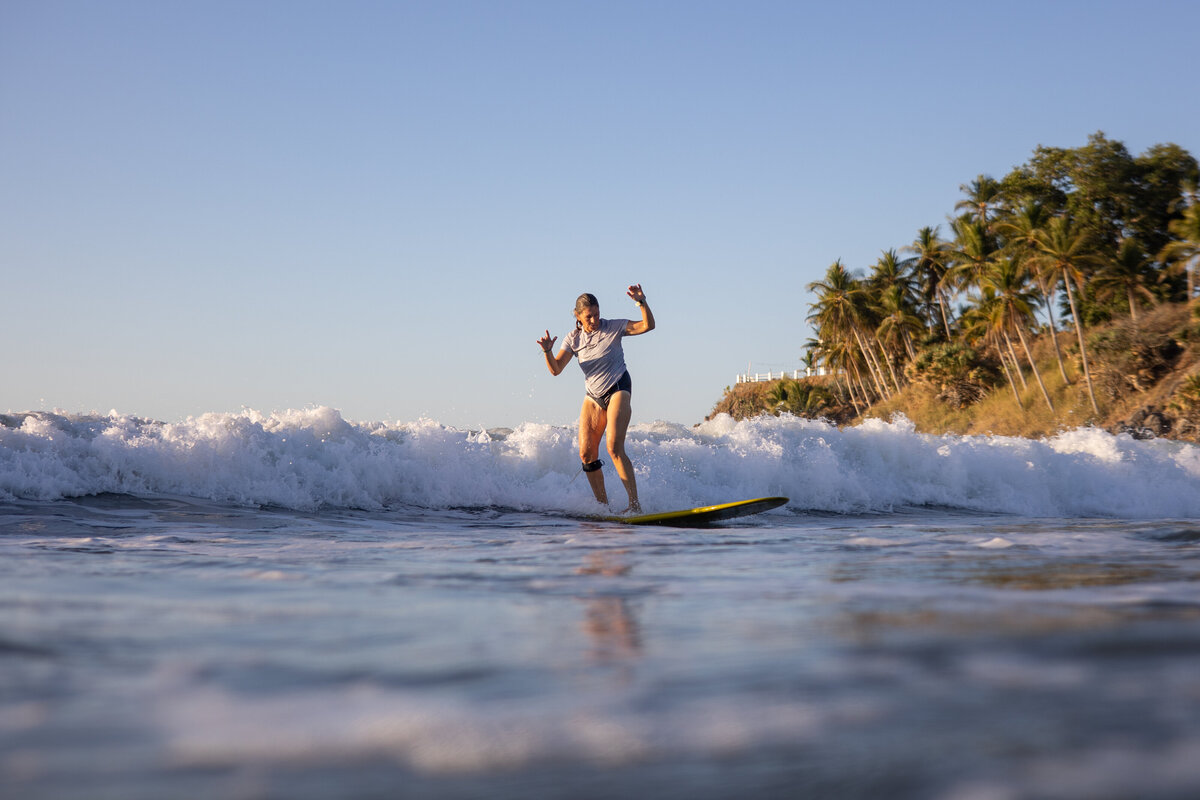 Surfer rides wave while on surf retreat in El Salvador