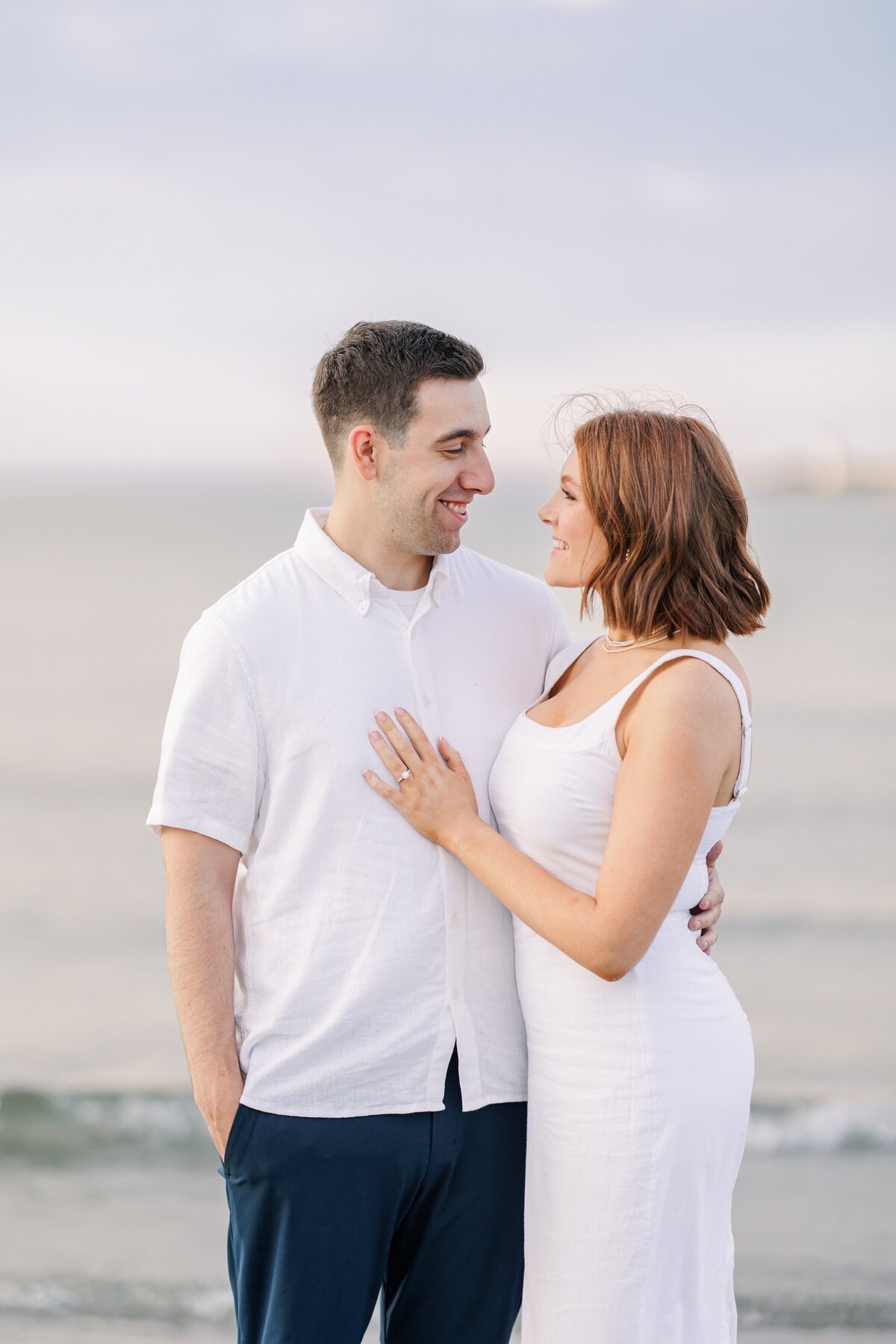 A couple hugging and smiling during their Gloucester engagement photos.