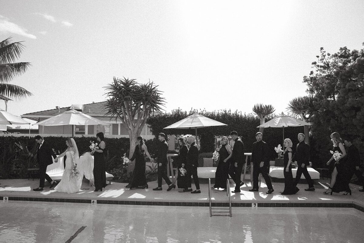 wedding party hangs out by pool after wedding in san diego
