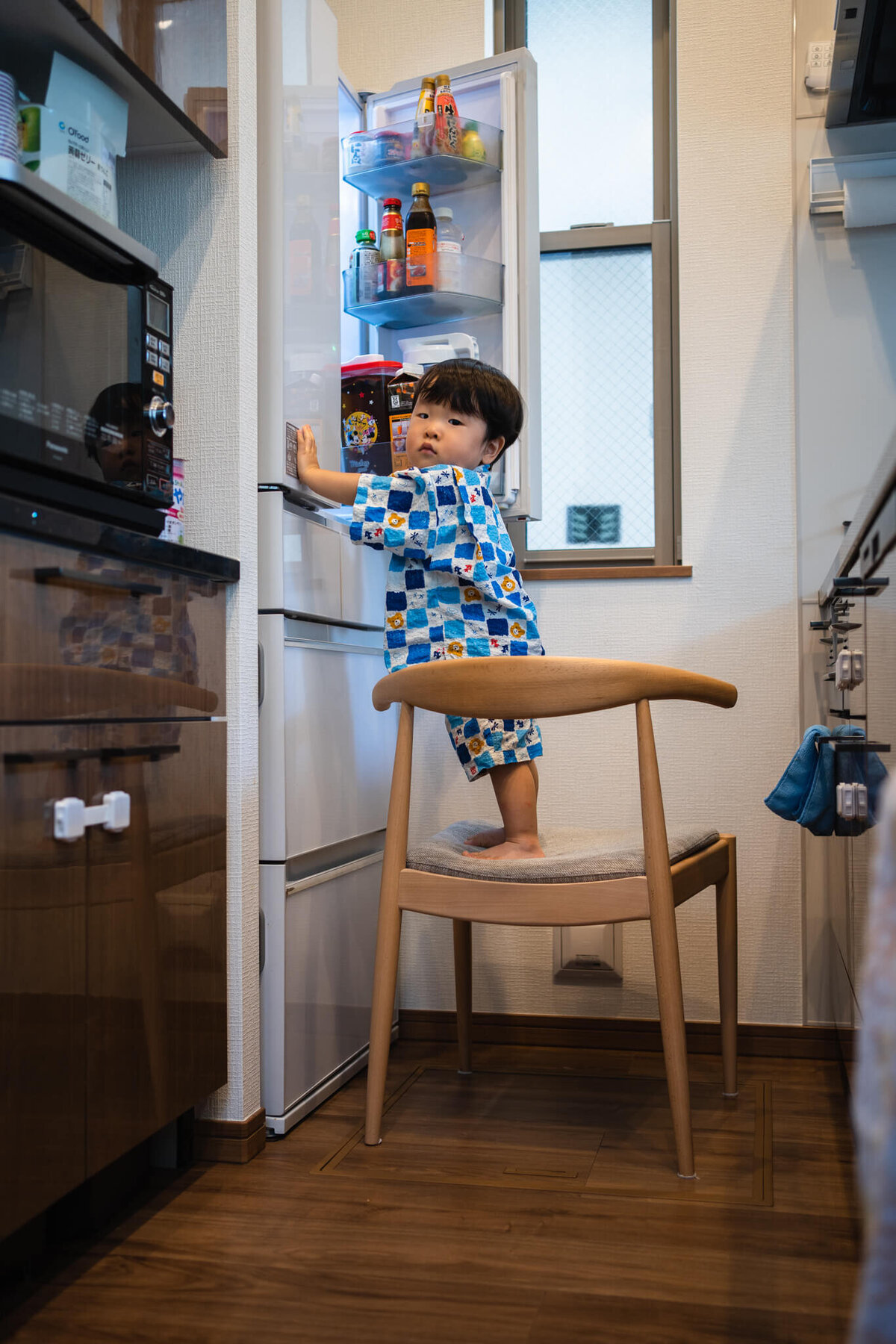 子供が冷蔵庫を開けている写真