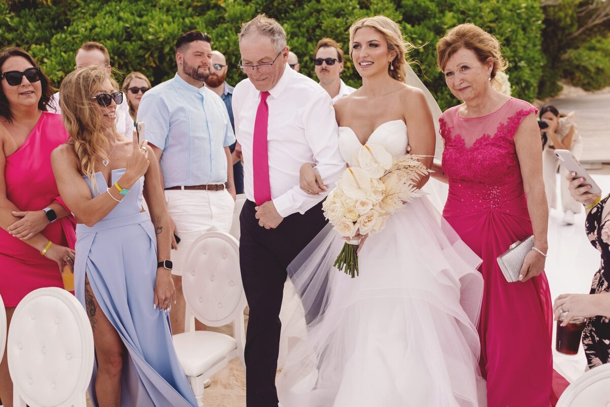 Bride walking down aisle with parents at  Iberostar Paraiso Riviera Maya Wedding