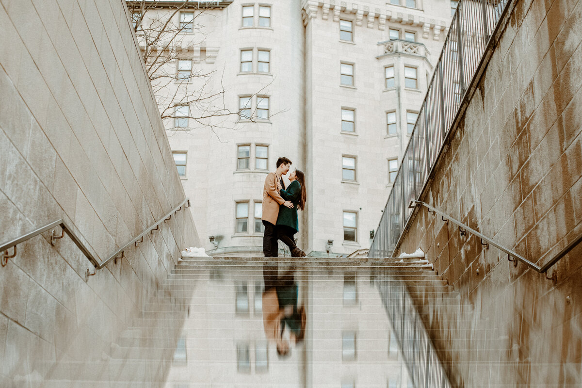 engaged-couple-looking-at-each-other-at-the-top-of-the-stairs-in-front-of-the-chateau-laurier-1