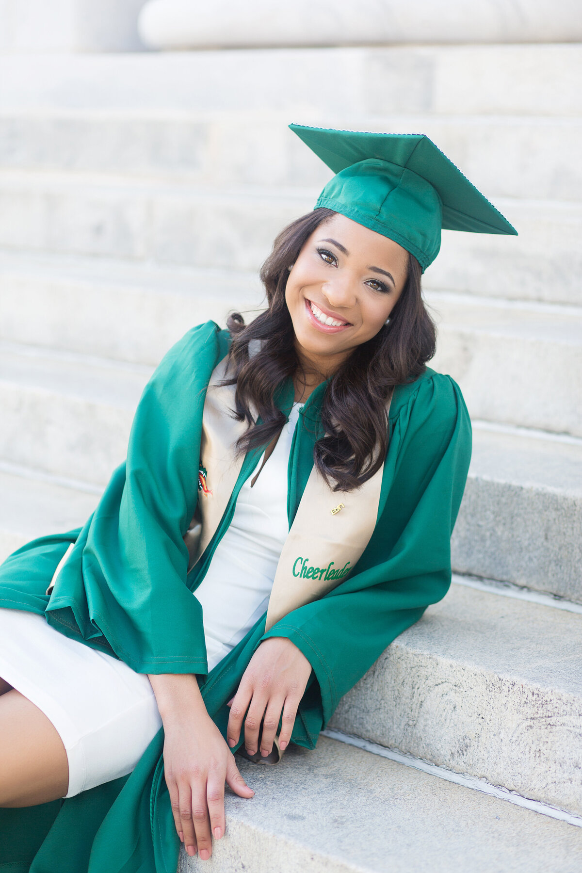 UAB Cheerleader sitting on the stair in front of the Federal Building for her Birmingham grad session.