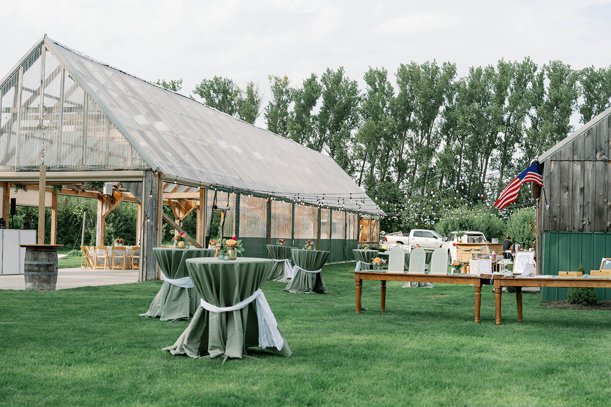 Wide exterior view of the Cherry Barn reception building nestled in the apple orchard during a fall wedding in Frankfort, Michigan.