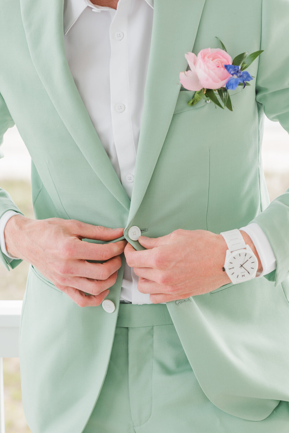 Groom getting ready on his wedding day with green suit