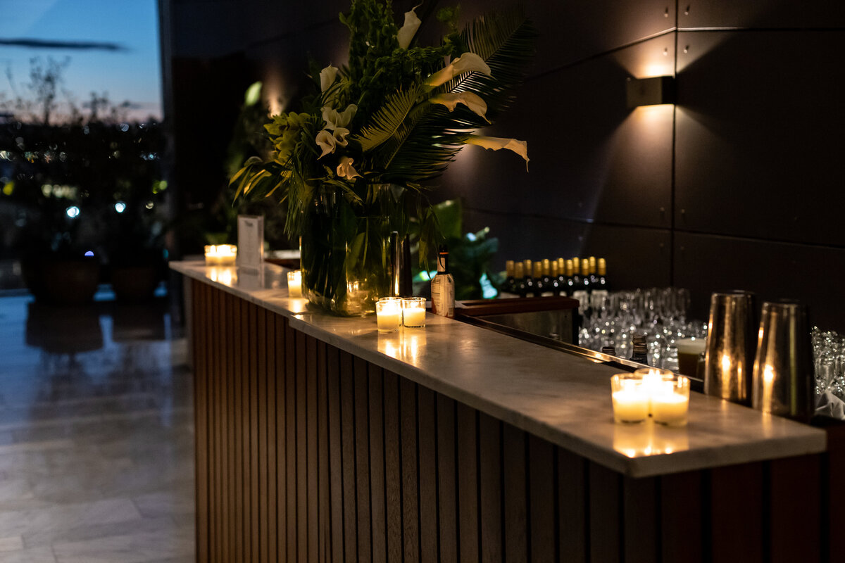 Candlelit bar decorated with floral arrangements.