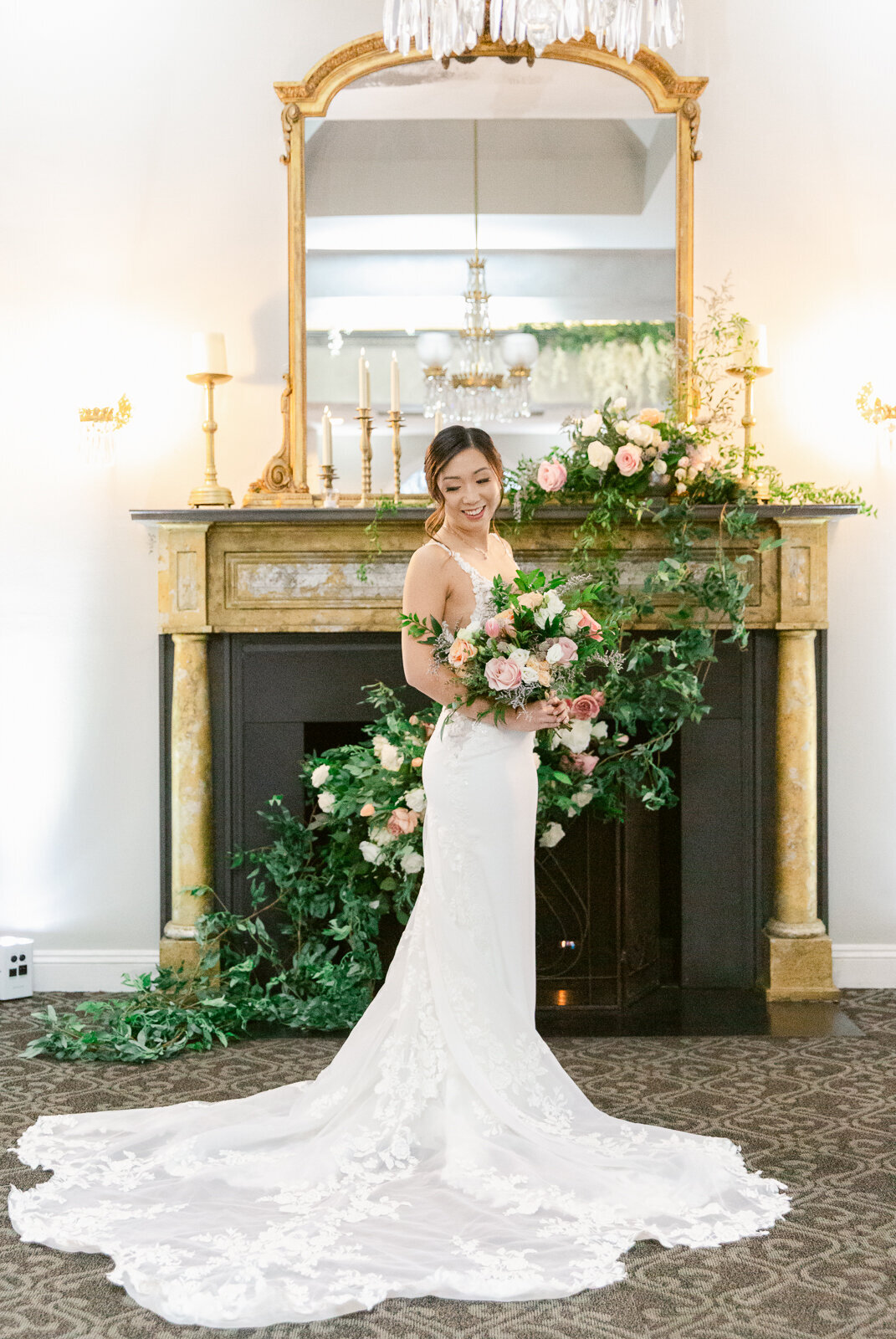 Bride taking portraits in front of the fireplace at Ceresville Mansion in Frederick, Maryland. Captured by Bethany Aubre Photography.