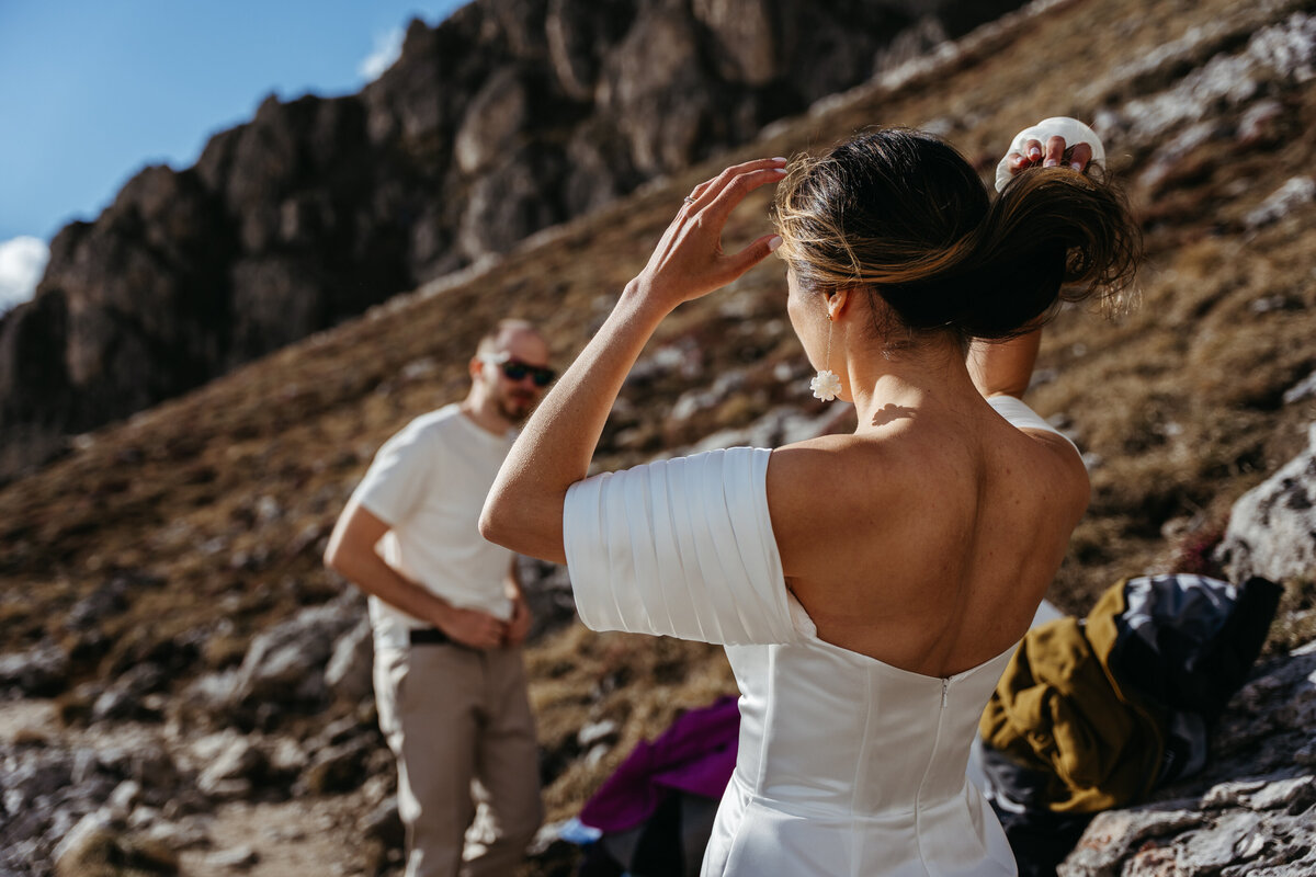 Bride adjusting hair while preparing for elopement in Dolomites