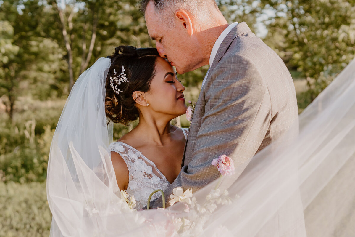 wedding-couple-portrait-kiss-forehead-emerald-hills-events-promise-city-iowa-des-moines-wedding-photographer-storyteller-collective-photo-co