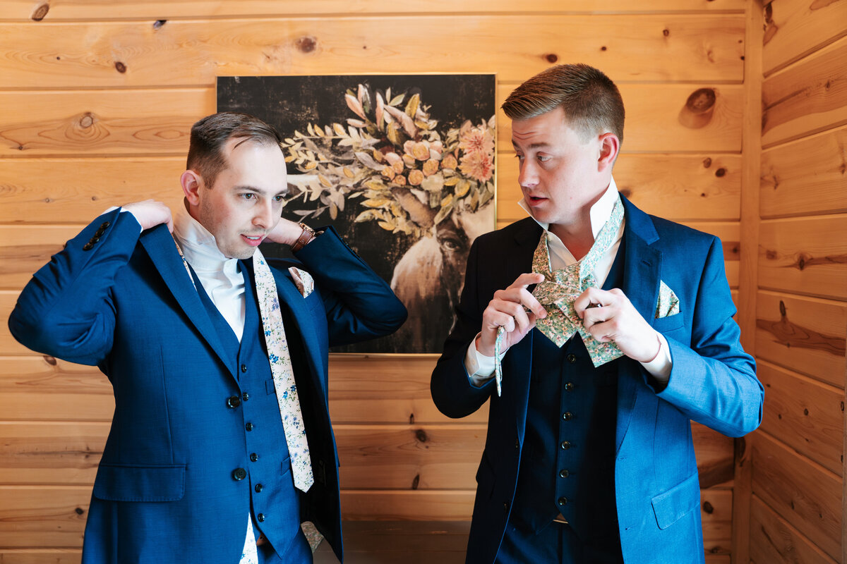 Candid moment of the groom adjusting his tie before the ceremony