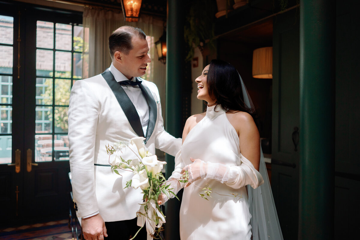 Bride and groom smiling together inside Hotel Chelsea in New York City during Japna and Chris’s romantic elopement, captured by NYC wedding photographer Perry Hancock.