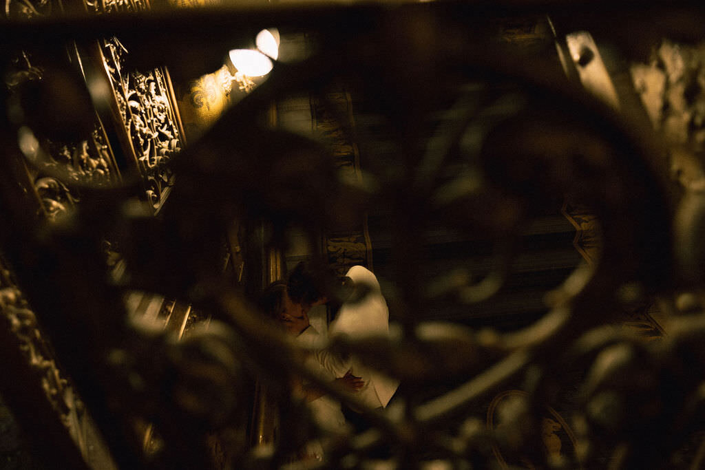 A couple kissing seen through the railing of a hotel