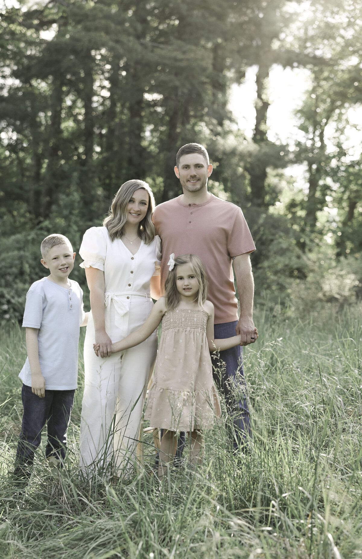 posed family of four in a field by Gracious Life Photography
