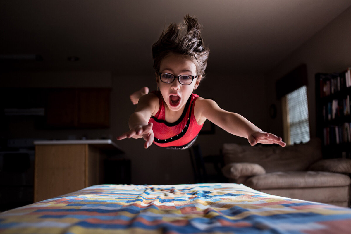 gymnast playing on mattress in living room