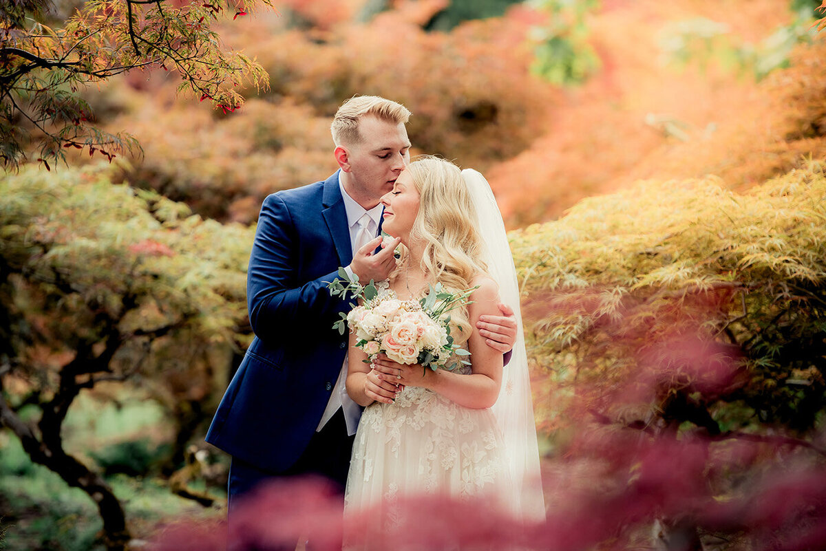 bride and groom in fall leaves