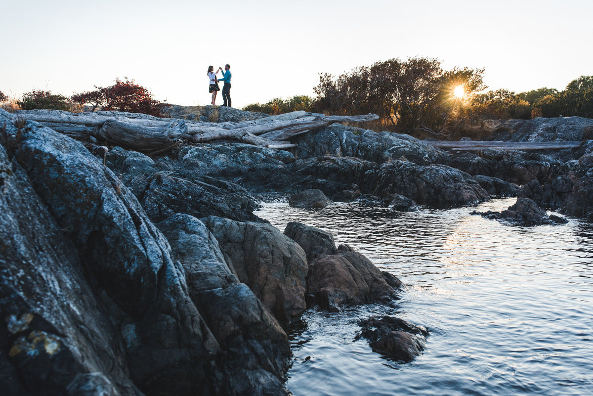 Couple dancing on the rocks in front of the ocean