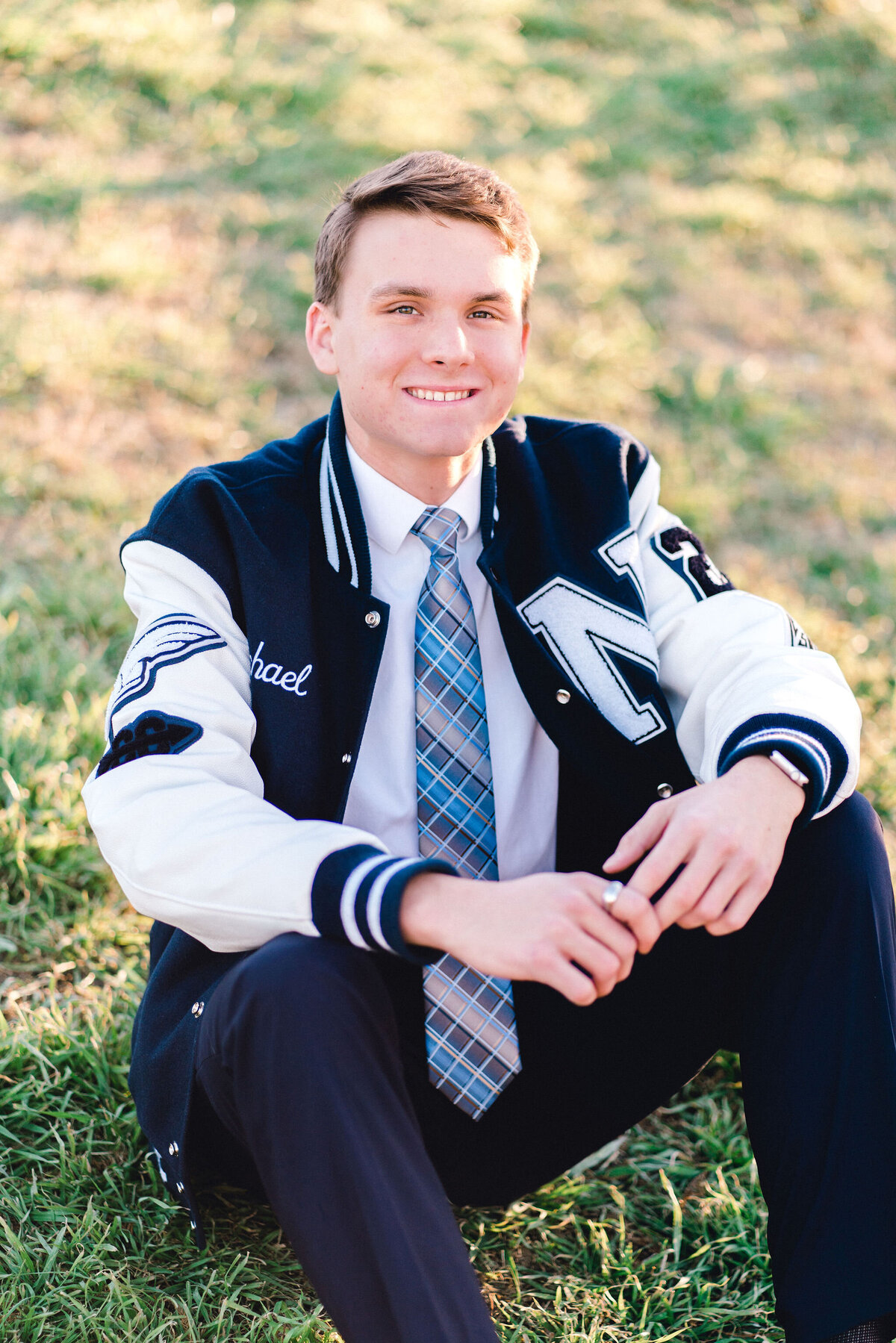Austin senior boy in letterman jacket. Outside in Austin Texas.