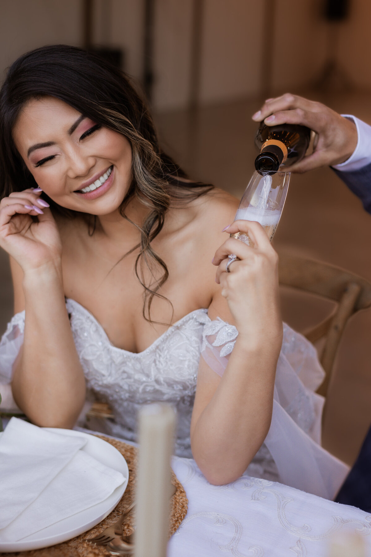 Asian bride being poured more champagne.